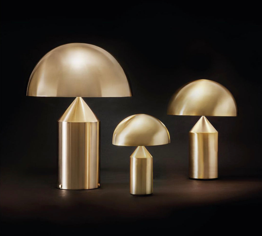 Sfeervol interieur met een iconische, sculpturale Oluce designlamp die een warme gloed in de woonkamer verspreidt