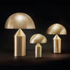 Sfeervol interieur met een iconische, sculpturale Oluce designlamp die een warme gloed in de woonkamer verspreidt