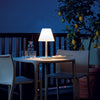 Een sfeervol verlicht terras in de avond met stijlvolle, draadloze oplaadbare lampen voor buiten op een tafel